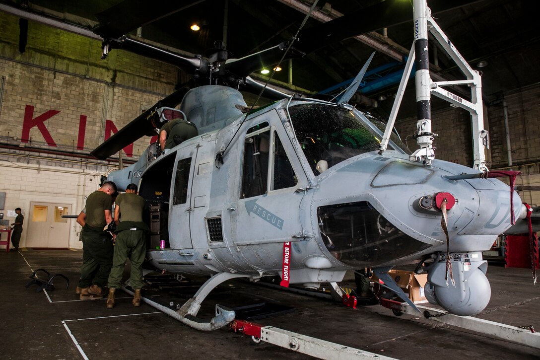Marines begin the installation of newly received auxiliary fuel tanks for the UH-1Y Venom at Marine Corps Air Station Futenma, Okinawa, Japan, June 14, 2016. “We have never installed these in the fleet, which the Marines here with the engineers are accomplishing today,” said Maj. Carl A. Bailey, the executive officer of Marine Light Attack Helicopter Squadron 469, Marine Aircraft Group 39, 3rd Marine Aircraft Wing, currently assigned to Marine Aircraft Group 36, 1st Marine Aircraft Wing through the Unit Deployment Program. “These are going to extend our range, our time on station and enable us to self-deploy throughout the Pacific area of operations. Our goal is to self-deploy to the Philippines, and if we can do that, we will not need C-17s, C-5s or any other aircraft. We won’t have to break down our own aircraft, we will just strap on the tanks and go.” The Marines are with HMLA 469. (U.S. Marine Corps photo by Cpl. Tyler S. Giguere)