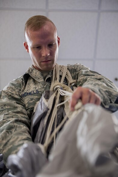 U.S. Air Force Tech. Sgt. Matthew Michels, 31st Rescue Squadron aircrew flight equipment assistant NCO in charge, flakes and folds a parachute canopy June 20, 2016, at Kadena Air Base, Japan. Michels' attention to detail and adherence to safety standards play a crucial part in preserving the lives of pararescuemen who don the chutes when jumping out of aircraft. (U.S. Air Force photo by Senior Airman Peter Reft)