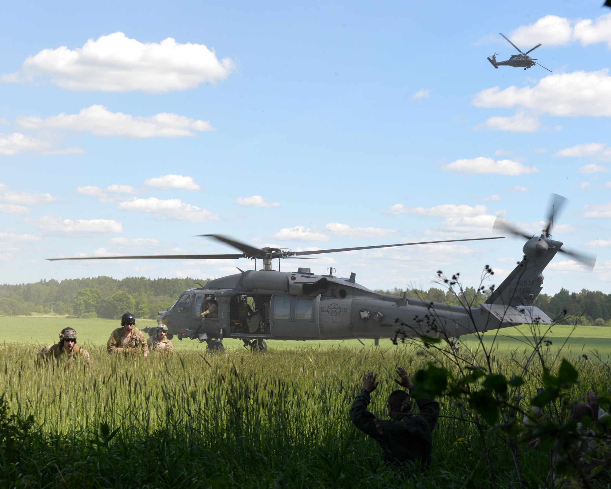Pararescue jumpers from the 103rd Rescue Squadron exit a U.S. Air Force HH-60 Pave Hawk helicopter and prepare to pick up two isolated personnel during Saber Strike 16 at Amari Air Base, Estonia June 14, 2016. Saber Strike is a multinational exercise that tests the capabilities of various aspects of the militaries involved. (U.S. Air National Guard photo/Staff Sgt. Blake Mize/released)