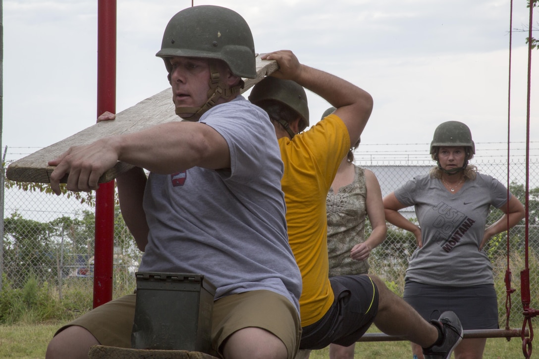 Taylor Walkenhorst and his team maneuver an obstacle at the Leadership Reaction Course (LRC) on Officer Candidates School aboard Marine Corps Base Quantico, Va., June 21 as part of the 2016 Key Leaders and Educators Workshop. Approximately 40 educators split up into teams of four to complete the LRC. The workshop includes events such as infantry patrolling, flight simulations and many others to provide a robust understanding of what it takes to create Marine officers. That understanding creates a mutually beneficial relationship between the educators and the Marine Corps and allows educators to guide their students who show interest in becoming Marine officers. Walkenhorst is a linebacker coach for Arizona Western College in Yuma, Az.