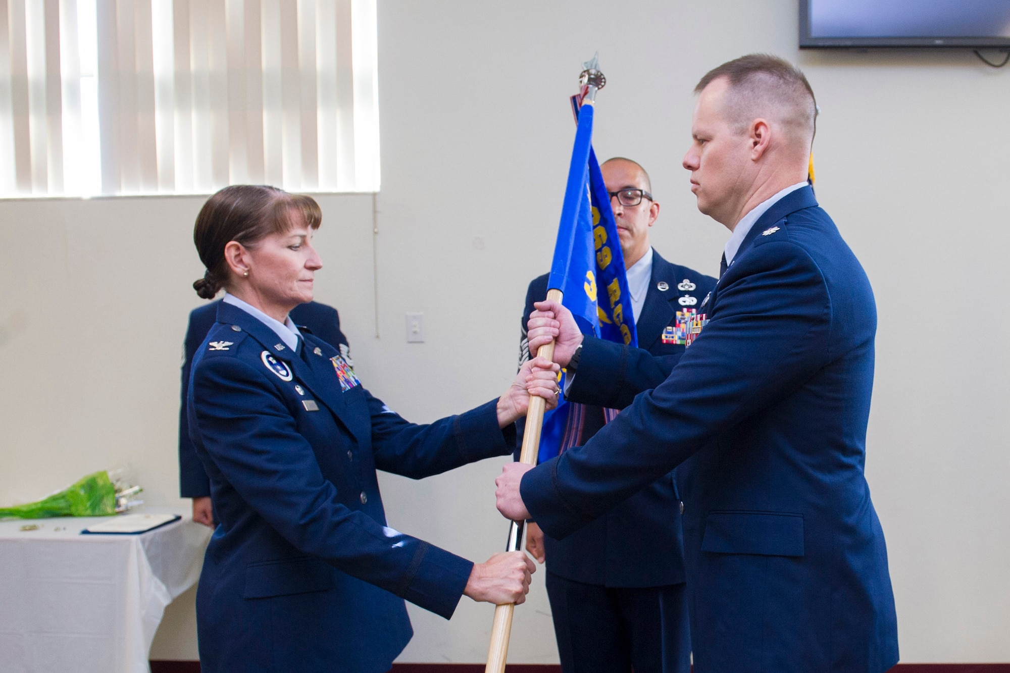 Col. Patricia Sergey, 369th Recruiting Group commander, presents Lt. Col. Joseph Roth, 333rd Recruiting Squadron commander, with the guidon during a change of command ceremony June 21, 2016, at Patrick Air Force Base, Fla. Changes of command are a military tradition representing the transfer of responsibilities from the presiding official to the upcoming official. (U.S. Air Force photo/James S. Rainier/Released)