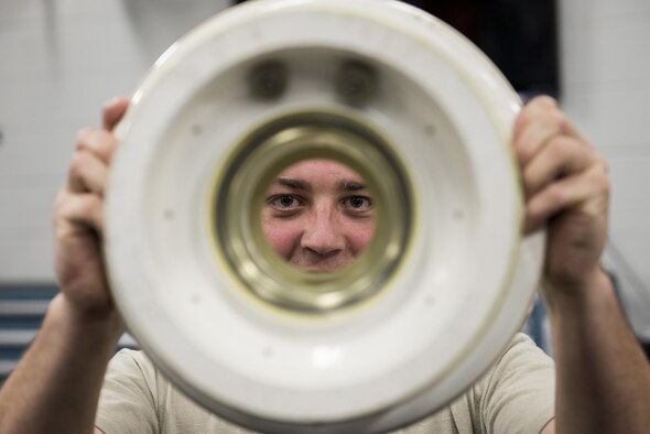 Staff Sgt. Mark Gower, 33rd Maintenance Squadron wheel and tire technician, looks through the opening of an F-35 wheel June 9, 2016, at Eglin Air Force Base, Fla. The 33rd MXS Wheel and Tire Shop builds an average of 50 a month for F-35s stationed at Eglin AFB. (U.S. Air Force photo by Senior Airman Stormy Archer/Released)