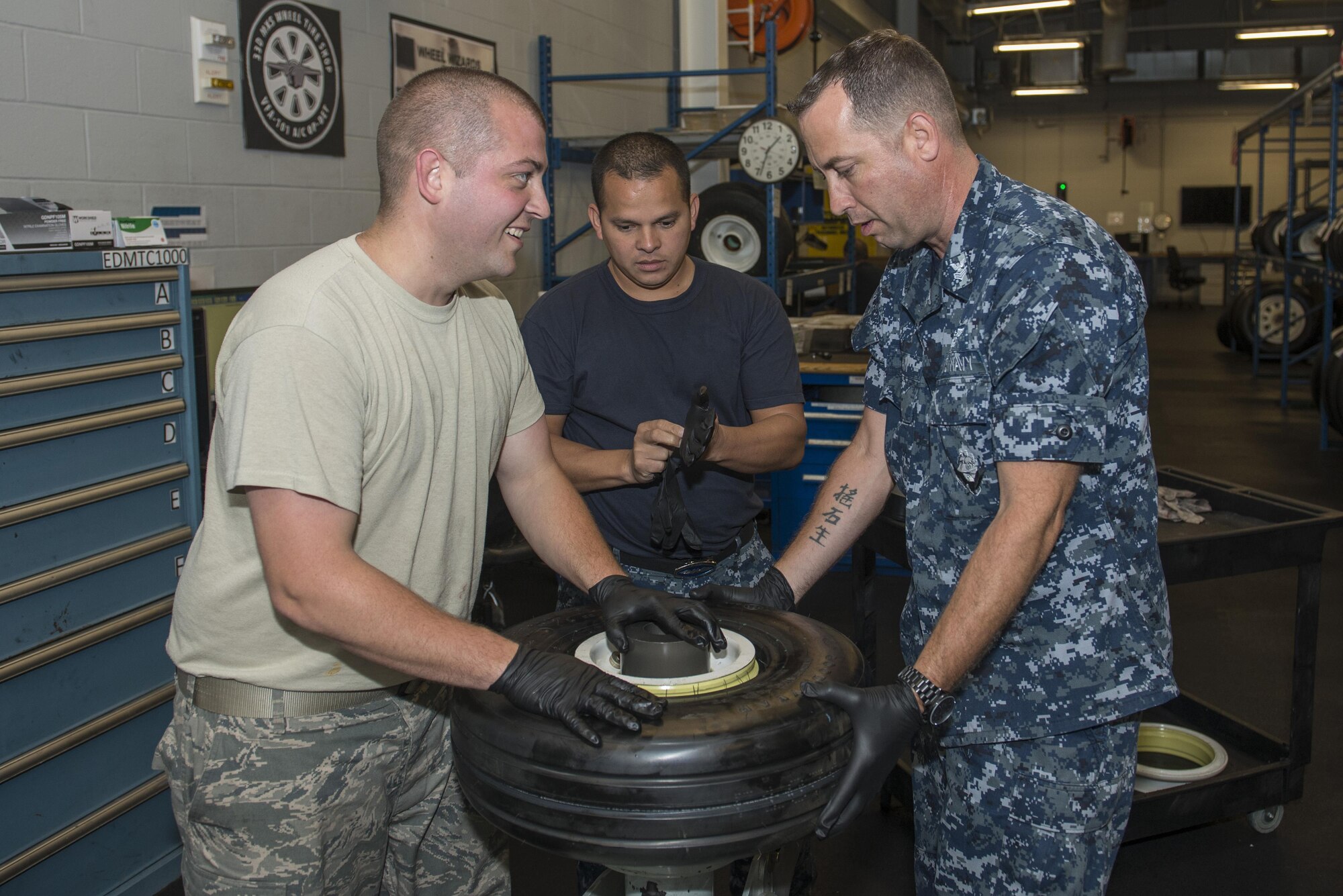 Staff Sgt. Mark Gower, 33rd Maintenance Squadron wheel and tire technician, Petty Officer 2nd Class Carlos Mazza, 33rd MXS aviation structural mechanic, and Petty Officer 1st Class Fredrick Logan 33rd MXS aviation structural mechanic, assemble an F-35 wheel June 9, 2016, at Eglin Air Force Base, Fla. The F-35 Wheel and Tire Shop at Eglin AFB is the only wheel and tire shop in the F-35 program that is integrated with both Air Force and Navy personnel. (U.S. Air Force photo by Senior Airman Stormy Archer/Released)