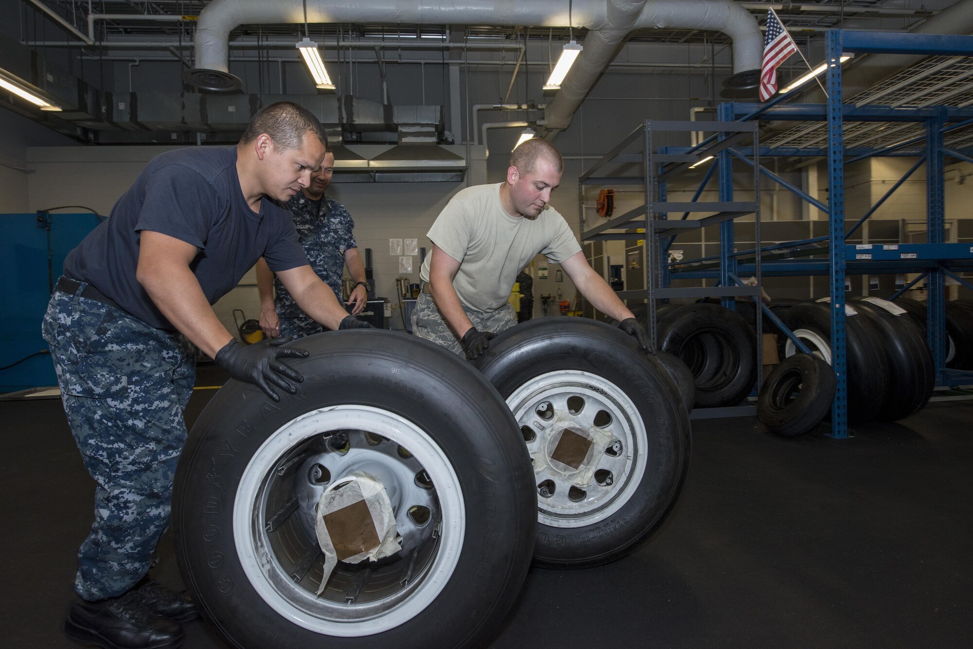 Staff Sgt. Mark Gower, 33rd Maintenance Squadron wheel and tire technician, and Petty Officer 2nd Class Carlos Mazza, 33rd MXS aviation structural mechanic roll used F-35 tires into the 33 rd MXS Wheel and Tire Shop June 9, 2016. The F-35 Wheel and Tire Shop at Eglin AFB is the only wheel and tire shop in the F-35 program that is integrated with both Air Force and Navy personnel. (U.S. Air Force photo by Senior Airman Stormy Archer/Released)