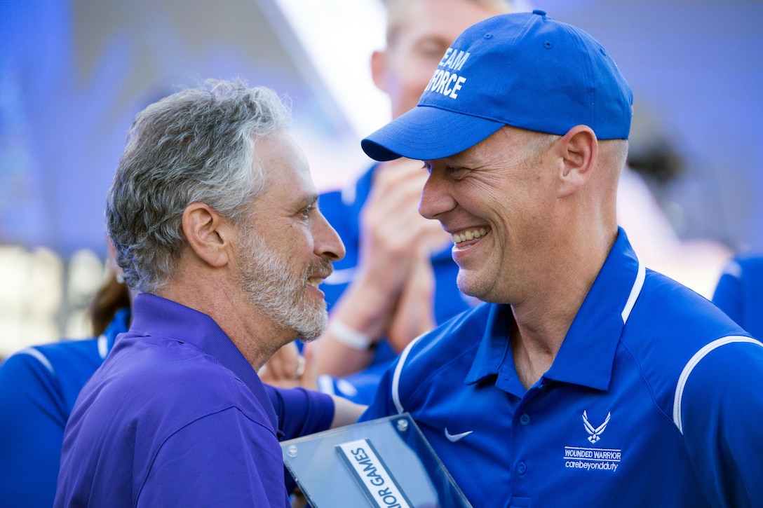 Comedian Jon Stewart, left, presents retired Air Force Capt. Chris Cochrane the Heart of Team Award for the Air Force team during the closing ceremony for the 2016 Department of Defense Warrior Games at the U.S. Military Academy in West Point, N.Y., June 21, 2016. DoD photo by EJ Hersom 