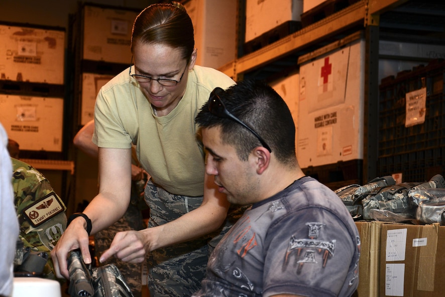 U.S. Air Force Tech. Sgt Jennifer Lotan, left, 379th Expeditionary Medical Support Squadron noncommissioned officer in charge of war rescue material, assists Staff Sgt. Michael Sanchez, 379th Operation Silent Sentry space systems operator, put together a joint first aid kit (JFAK) at Al Udeid Air Base, Qatar, June 15, 2016. Sanchez was one of more than 60 volunteers who assisted in the inspection and construction of more than 1,000 JFAKs.
(U.S. Air Force photo by Senior Airman Kimberly Nagle)