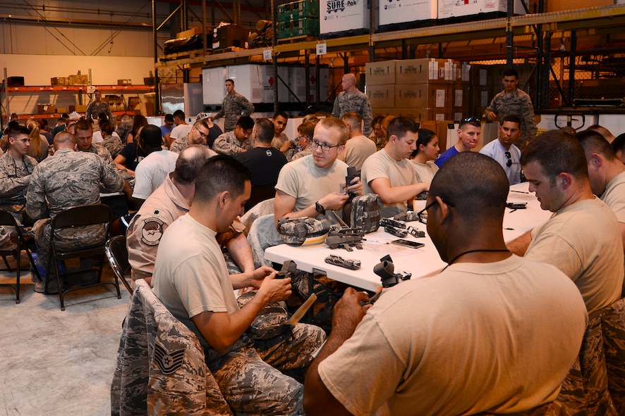 Volunteers inspect and assemble joint first aid kits (JFAK) at Al Udeid Air Base, Qatar, June 15, 2016. More than 60 volunteers, to include service members and Command Sponsorship Program spouses, participated in the JFAK building event. (U.S. Air Force photo by Senior Airman Kimberly Nagle)
