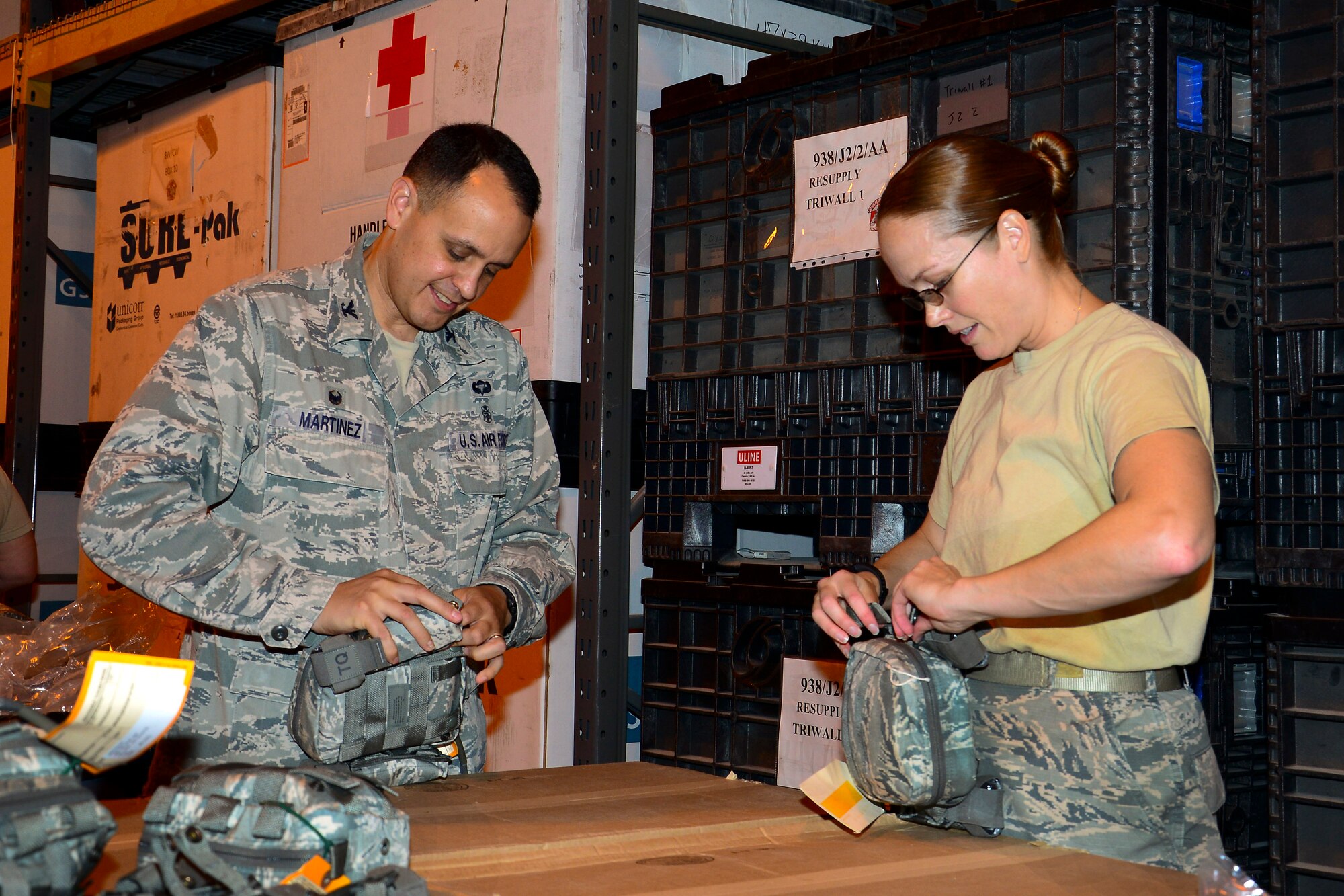 U.S. Air Force Col. Timothy Martinez, 379th Expeditionary Medical Group commander, builds and inspects a joint first aid kit (JFAK) with Tech. Sgt Jennifer Lotan, right, 379th Expeditionary Medical Support Squadron noncommissioned officer in charge of war rescue material, at Al Udeid Air Base, Qatar, June 15, 2016. During the event, the group was able to inspect and build more than 1,000 JFAKs. (U.S. Air Force photo by Senior Airman Kimberly Nagle)