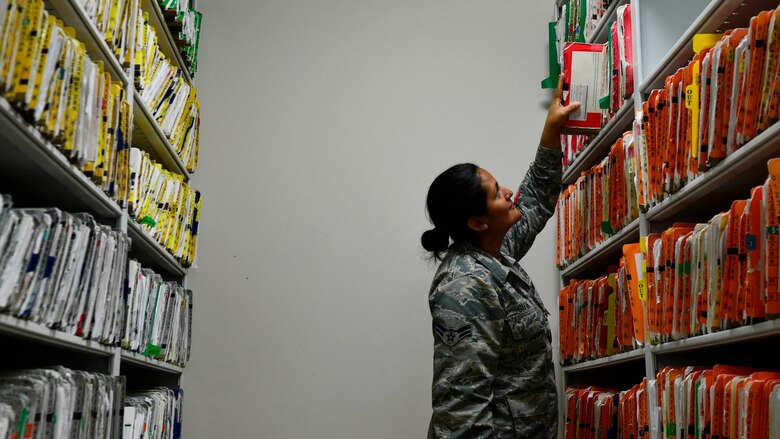Airman 1st Class Laura Gaitan, 31st Medical Support Squadron medical records technician, retrieves a Team Aviano member’s medical record for processing, June 20, 2016, at Aviano Air Base, Italy. The 31st MDSS medical records team stores and processes both electronic and paper medical records for in- and out-processing members. (U.S. Air Force photo by Airman 1st Class Cary Smith/Released)