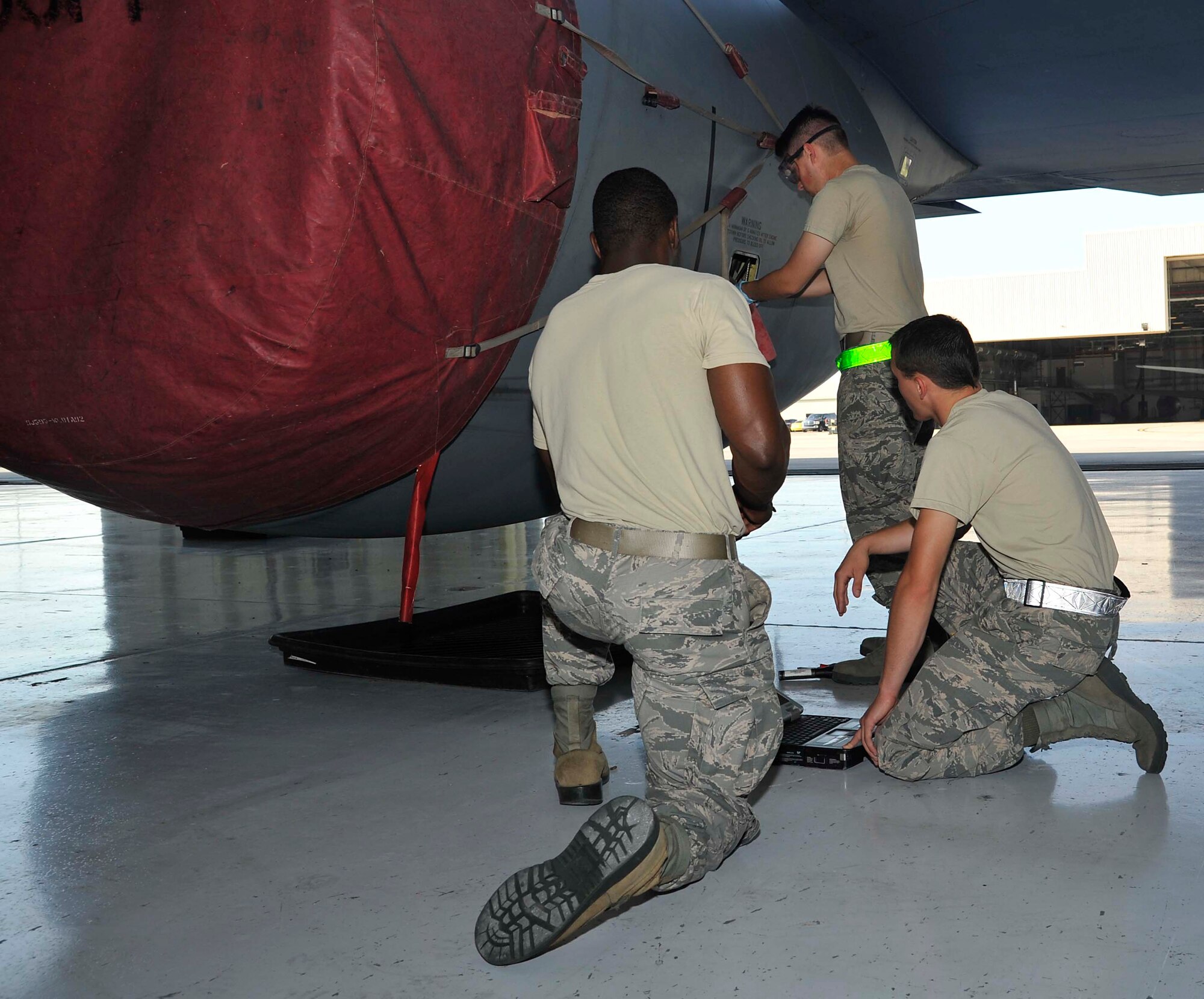 Airmen 1st Class Samuel Gebhart and Gregory Newsom, 22nd Aircraft Maintenance Squadron crew chiefs, simulate checking the engine oil level on a KC-135 Stratotanker for training, June 17, 2016, at McConnell Air Force Base, Kan. Engine oil is checked after every flight to ensure proper quantities are maintained. (U.S. Air Force photos/Airman Erin McClellan)