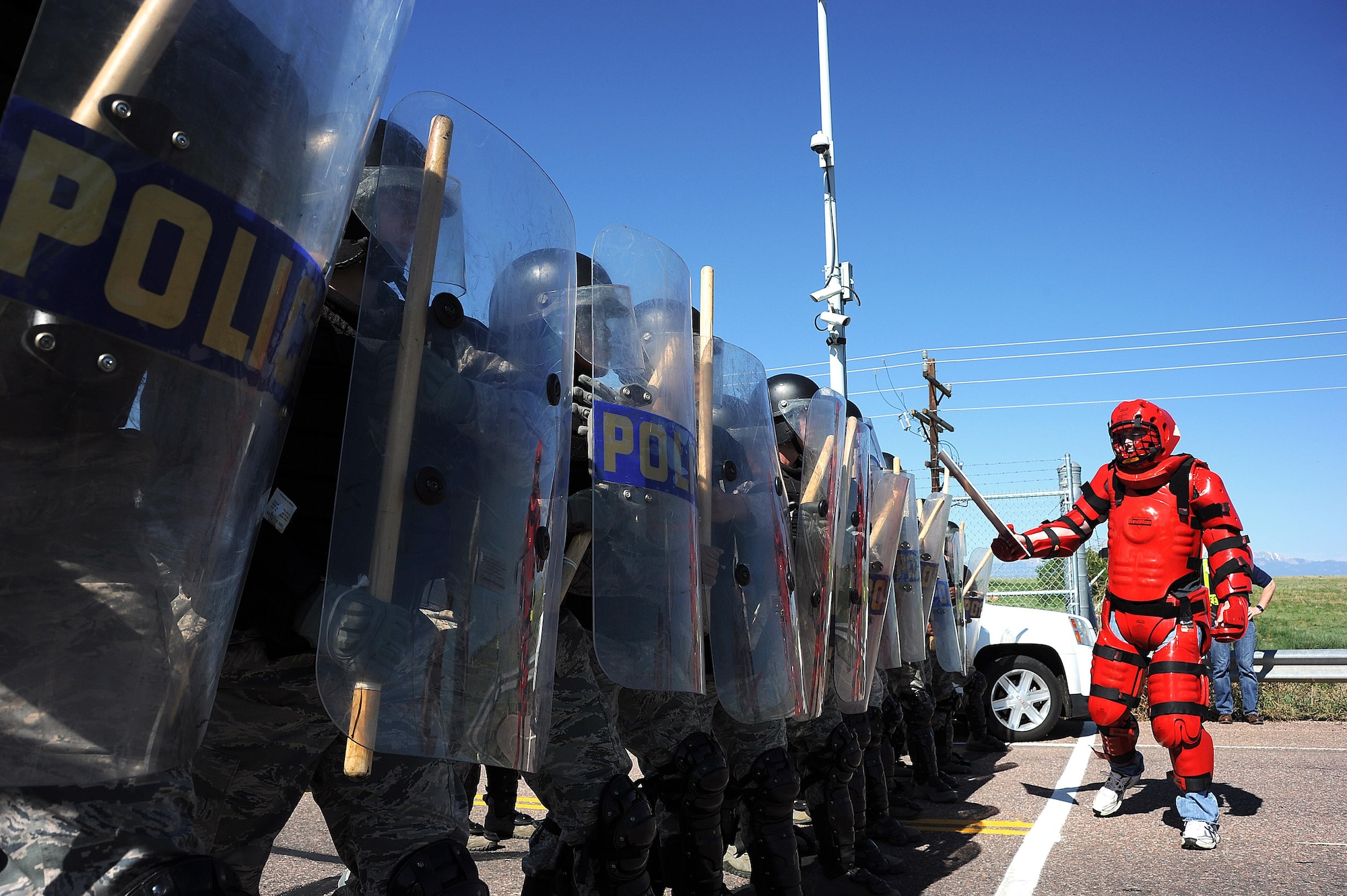 A protest actor engages 50th Security Forces Squadron defenders who stand at ready during a base exercise at Schriever Air Force Base, Colorado, Saturday, June 11, 2016. The exercise was designed to evaluate the base’s response to various incidents. (U.S. Air Force photo/Katie Calvert)