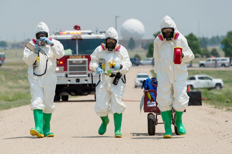 Twenty-first Medical Squadron bioenvironmental engineers advance toward a contaminated area to test for chemical agents during Opinicus Vista 16-2, a base exercise at Schriever Air Force Base, Colorado, Thursday, June 16, 2016. The Airmen remained fully suited throughout the exercise to practice as they’d respond real-world. (U.S. Air Force Photo/Dennis Rogers)