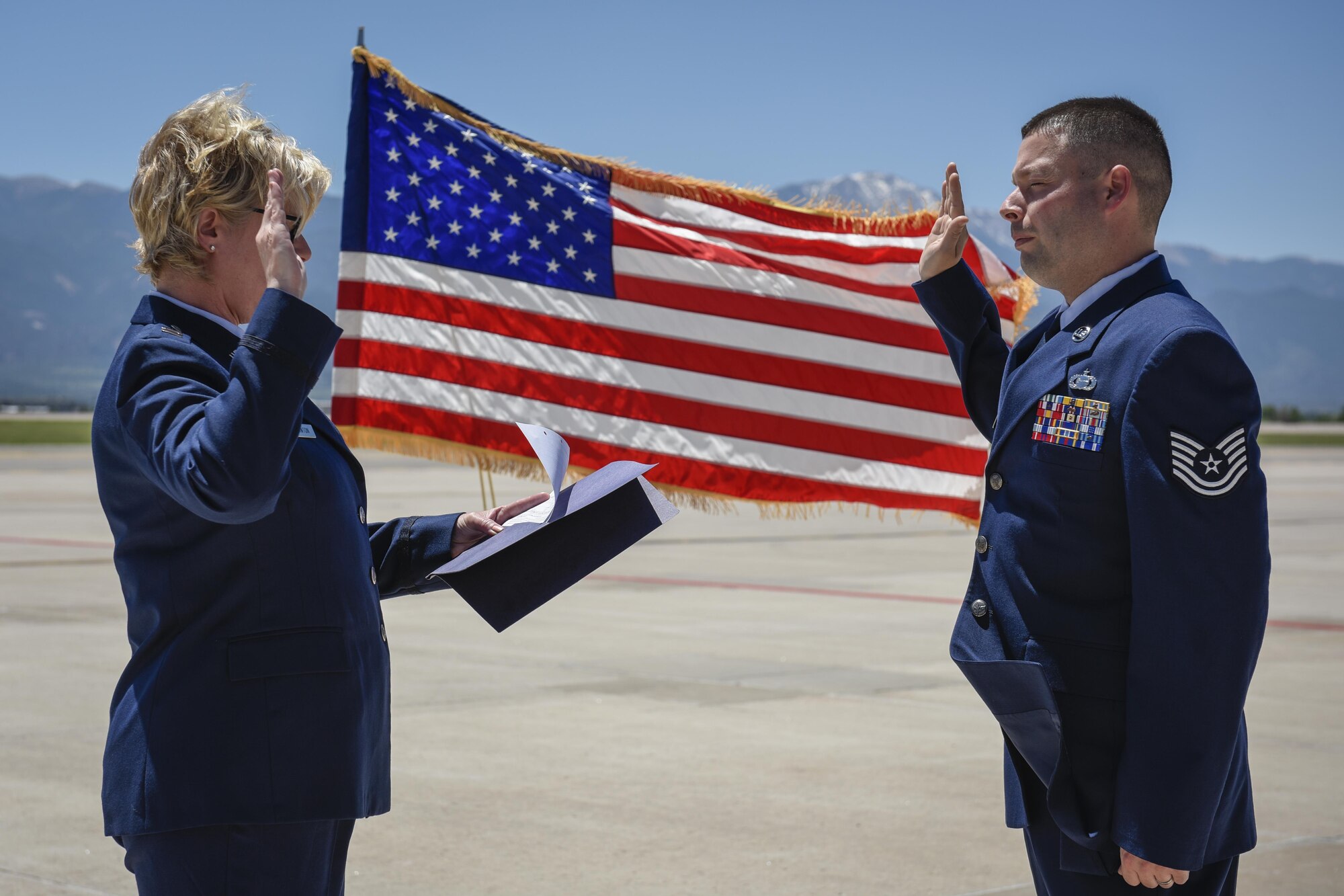 PETERSON AIR FORCE BASE, Colo. - Tech. Sgt. Sean Dastas, 21st Operations Support Squadron, right, recites the oath of enlistment back to his mother, Capt. Stephanie Lawton, 9th Medical Group at Beale Air Force Base, Calif., June 15, 2016. Dastas was reenlisted for another four years by his mother, who traveled from California for the occasion. (U.S. Air Force photo by Senior Airman Rose Gudex)