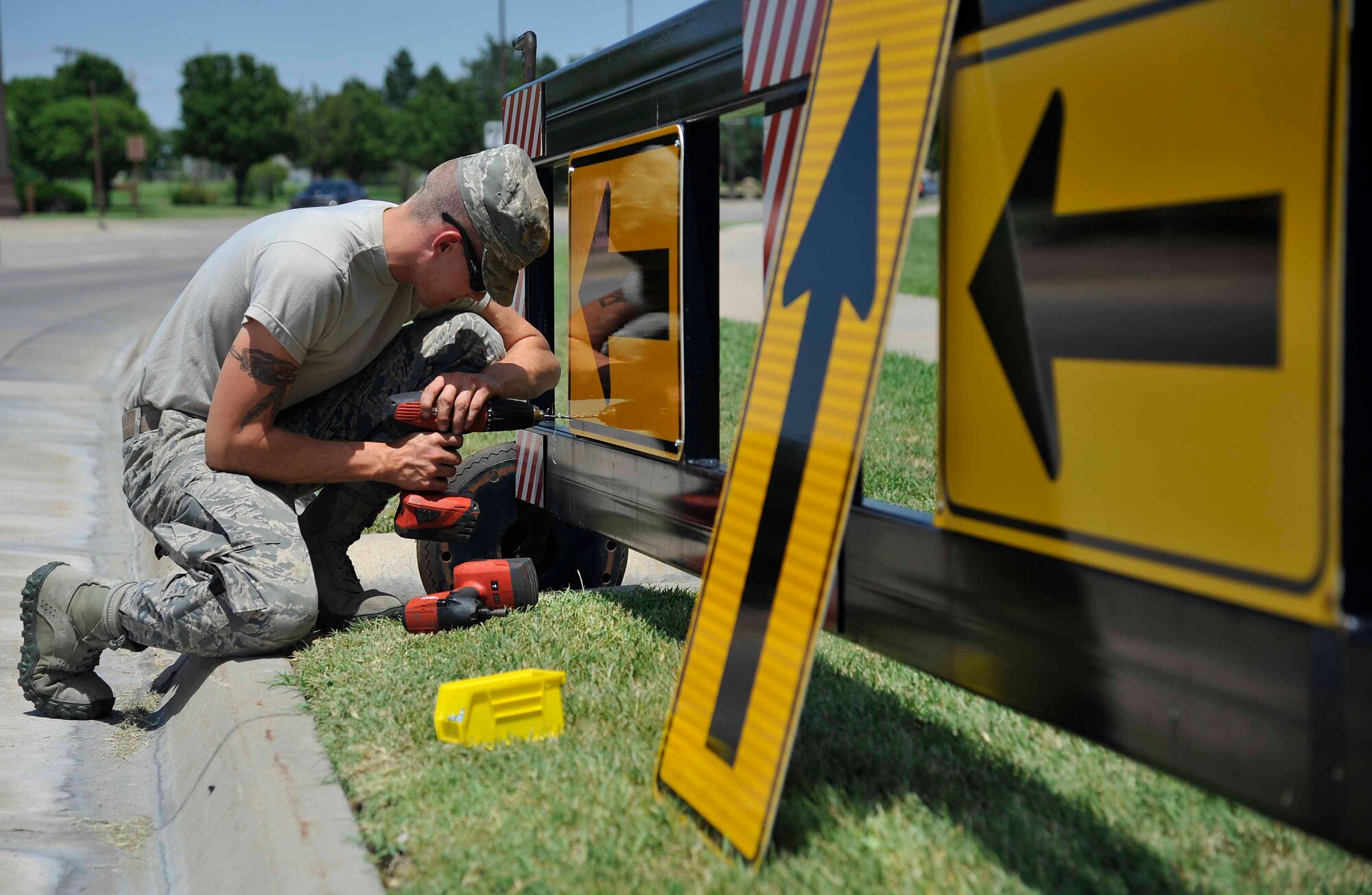 Airman 1st Class James Ori, 22nd Civil Engineer Squadron structures apprentice, replaces signs on serpentine barriers at the main gate, June 21, 2016, at McConnell Air Force Base, Kan. Barriers at the gate are used to help maintain safety and security on the base. (U.S. Air Force photos/Airman Erin McClellan)