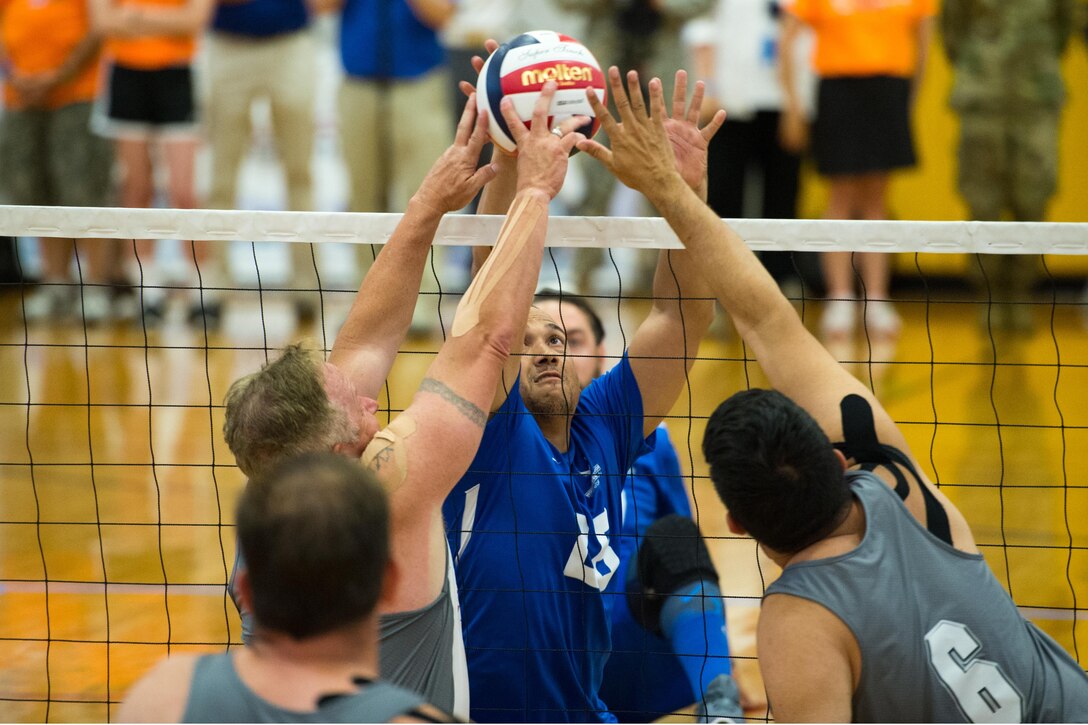 Air Force Tech Sgt. Brian Williams, center, battles at the net with Special Operations Command defenders during the finals sitting volleyball gold medal match of the 2016 Department of Defense Warrior Games volleyball event at the U.S. Military Academy in West Point, N.Y., June 21, 2016. DoD photo by EJ Hersom