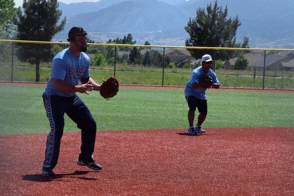 Staff Sgt. Matthew Brown, 361st Training Squadron, and Master Sgt. Junicio Cacal, 82nd Aerospace Medical Squadron, prepare to field a hit at military softball tournament in Colorado, June 13, 2016. The Sheppard Senators, Sheppard Air Force Base's men's varsity softball team, ranks first out of 57 Varsity 'B' military teams from around the country. 