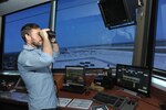 Jeremy Sebesta, 12th Operations Support Squadron, air traffic controller, looks for incoming aircraft, aircraft landing lights and birds at the East Control Tower, June 15, at Joint Base San Antonio-Randolph. Air traffic controllers keep planes a safe distance apart, advise on landings and alert planes to potential problems. 