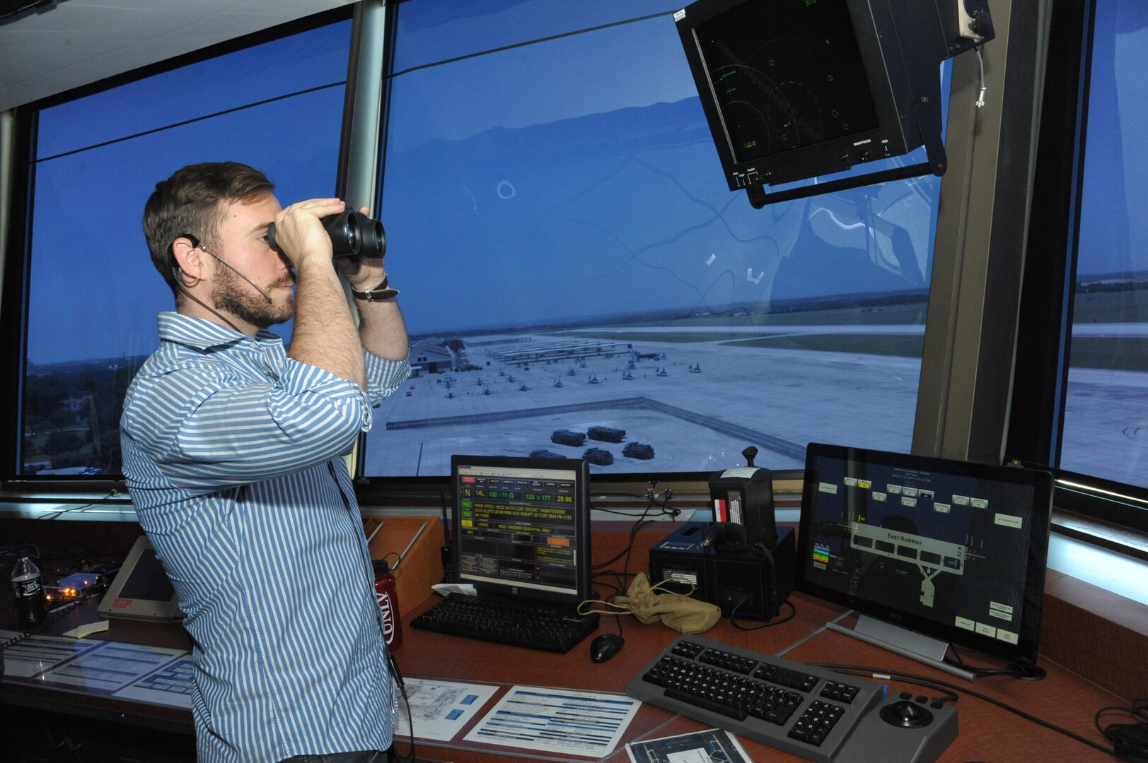 Jeremy Sebesta, 12th Operations Support Squadron, air traffic controller, looks for incoming aircraft, aircraft landing lights and birds at the East Control Tower, June 15, at Joint Base San Antonio-Randolph. Air traffic controllers keep planes a safe distance apart, advise on landings and alert planes to potential problems. 