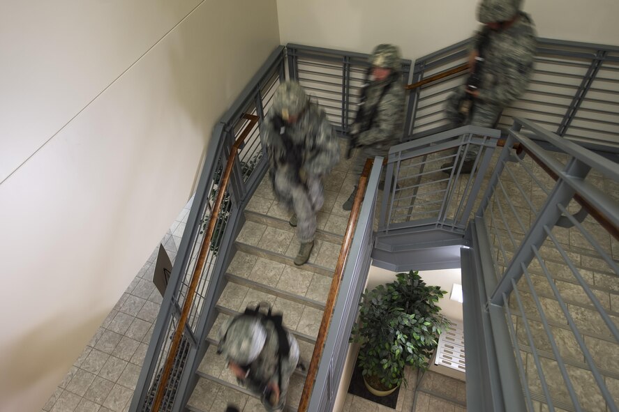 Defenders rush down a staircase in response to a simulated active-shooter threat at Schriever Air Force Base, Colorado, Thursday, June 16, 2016. The squadron played an important role in implementing security measures during different phases of the two-week exercise. (U.S. Air Force Photo/Dennis Rogers)