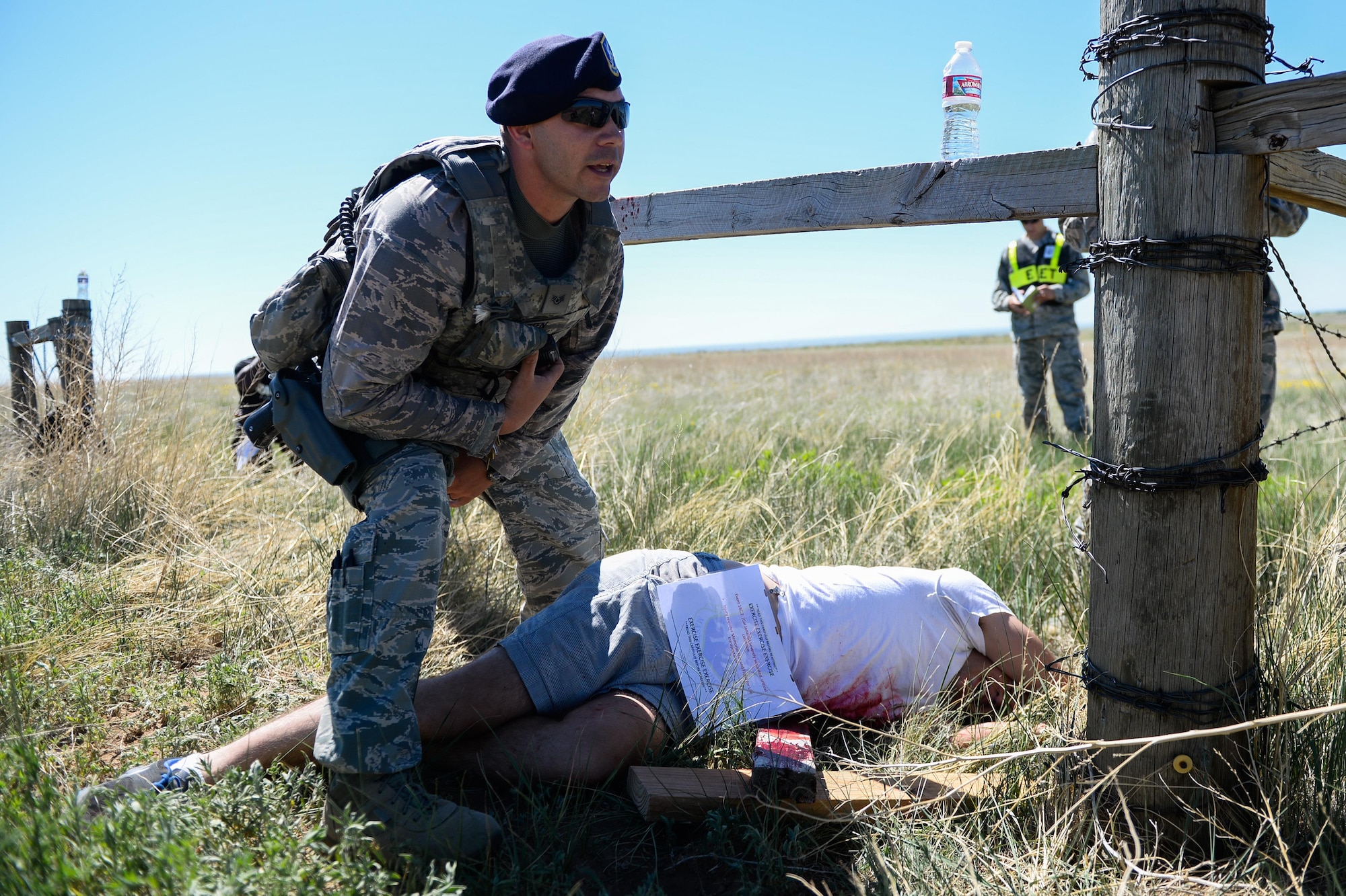 A 50th Security Forces Squadron defender tends to a victim during Opinicus Vista 16-2, a base exercise at Schriever Air Force Base, Colorado, Wednesday, June 15, 2016. Airmen played the part of victims to create realistic exercises. (U.S. Air Force photo/Christopher DeWitt)