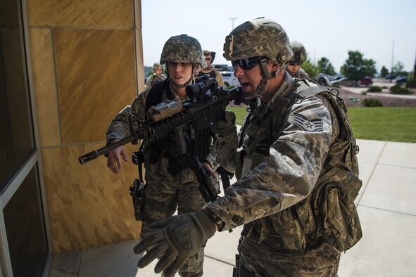 Defenders with the 50th Security Forces Squadron prepare to enter a building during an active-shooter exercise at Schriever Air Force Base, Colorado, Thursday, June 16, 2016. The scenario was a part of Opinicus Vista 16-2, a base exercise that tests Team Schriever’s readiness to respond during crisis scenarios. (U.S. Air Force Photo/Dennis Rogers)