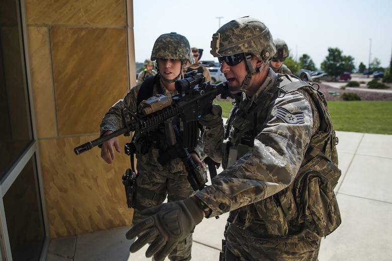 Defenders with the 50th Security Forces Squadron prepare to enter a building during an active-shooter exercise at Schriever Air Force Base, Colorado, Thursday, June 16, 2016. The scenario was a part of Opinicus Vista 16-2, a base exercise that tests Team Schriever’s readiness to respond during crisis scenarios. (U.S. Air Force Photo/Dennis Rogers)