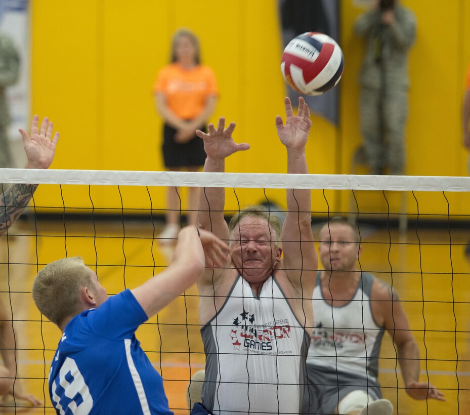 Air Force Capt. Michael Gentry, left, spikes the ball past Special Operations Command team members Edward O’Neil and Kyle Butcher, both veterans, during the sitting volleyball gold medal match of the 2016 Department of Defense Warrior Games at the U.S. Military Academy in West Point, N.Y., June 21, 2016. DoD photo by Roger Wollenberg