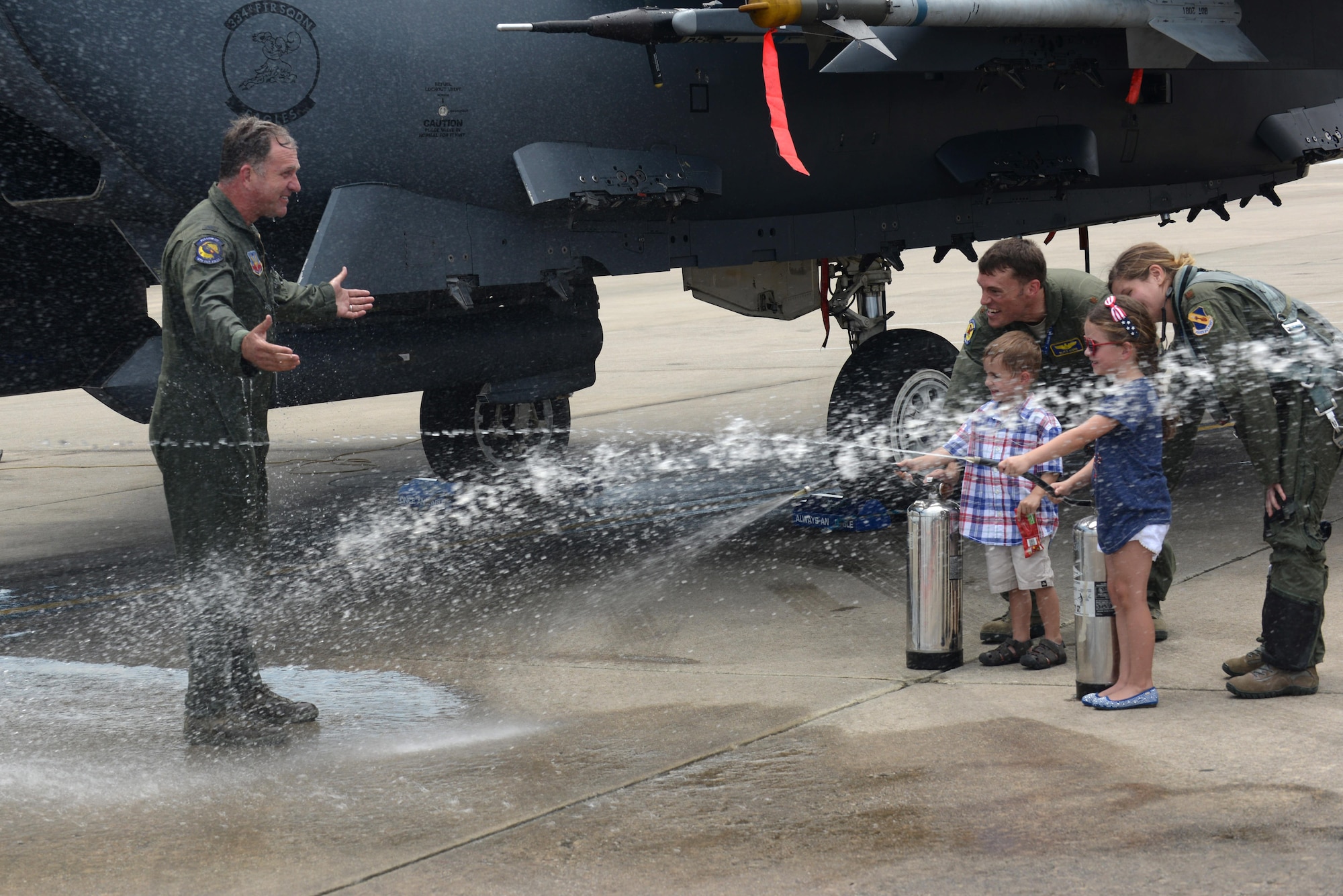 Col. Mark Slocum, 4th Fighter Wing commander, is hosed down by his children following his final flight in an F-15E Strike Eagle, June 16, 2016, at Seymour Johnson Air Force Base, North Carolina. Slocum will be promoted to brigadier general on June 29, 2016, before departing for a position at Royal Air Force Mildenhall, England. (U.S. Air Force photo/Airman 1st Class Ashley Williamson)