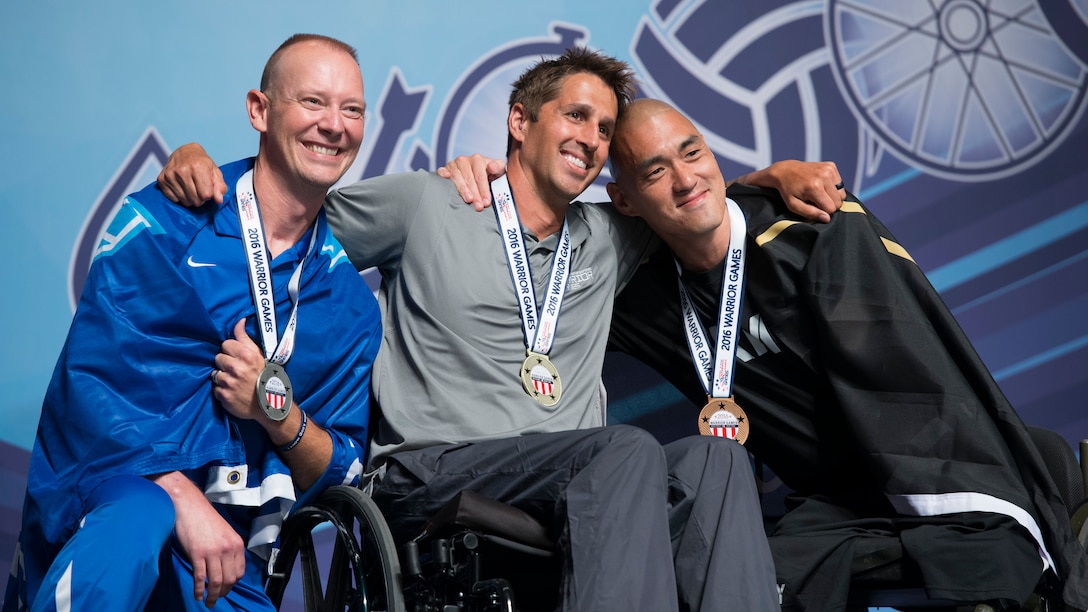 From left, Air Force veteran Christopher Cochrane; Navy Lt. Ramesh Haytasingh, a member of the U.S. Special Operations Command team; and Army veteran Matthew Lammers celebrate their medals in swimming during the 2016 Department of Defense Warrior Games at the U.S. Military Academy in West Point, N.Y., June 21, 2016. DoD photo by Roger Wollenberg