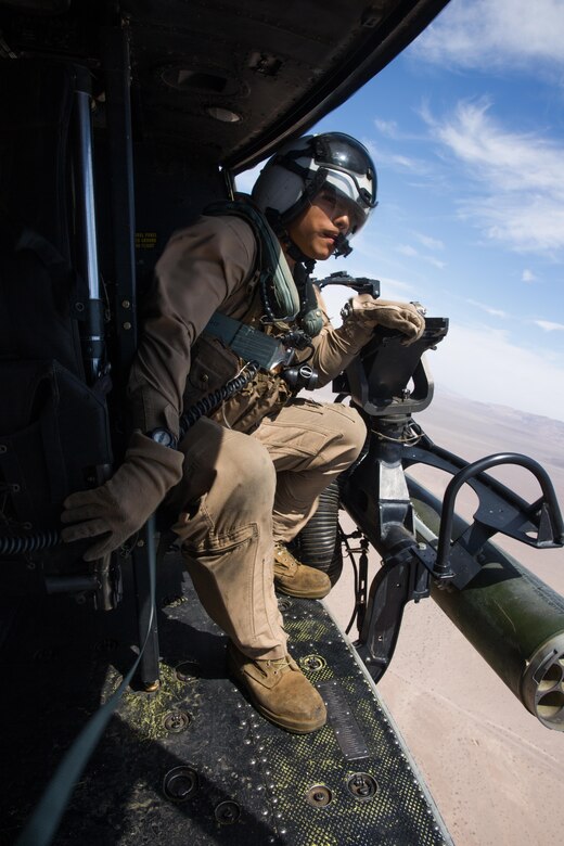 Lance Cpl. Servando Avila, a crew chief with Marine Light Attack Helicopter Squadron (HMLA) 267 “Stingers” and a Houston native, observes the location of a nearby aircraft above Marine Corps Air Ground Combat Center Twentynine Palms, Calif., June 10. Marines with HMLA-267 supported Marines with 3rd Battalion, 7th Marine Regiment during a close-air-support training mission aboard the combat center. (U.S. Marine Corps photo by Sgt. Lillian Stephens/Released)