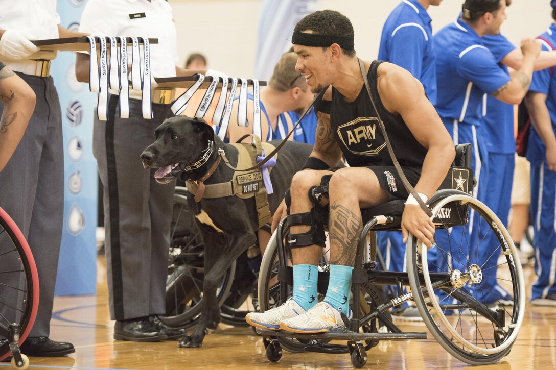 Army veteran Blake Johnson gets in position along with his service dog to receive his gold medal after the Army defeated the Marines in wheelchair basketball during the 2016 Department of Defense Warrior Games at the U.S. Military Academy in West Point, N.Y., June 21, 2016. DoD photo by Roger Wollenberg