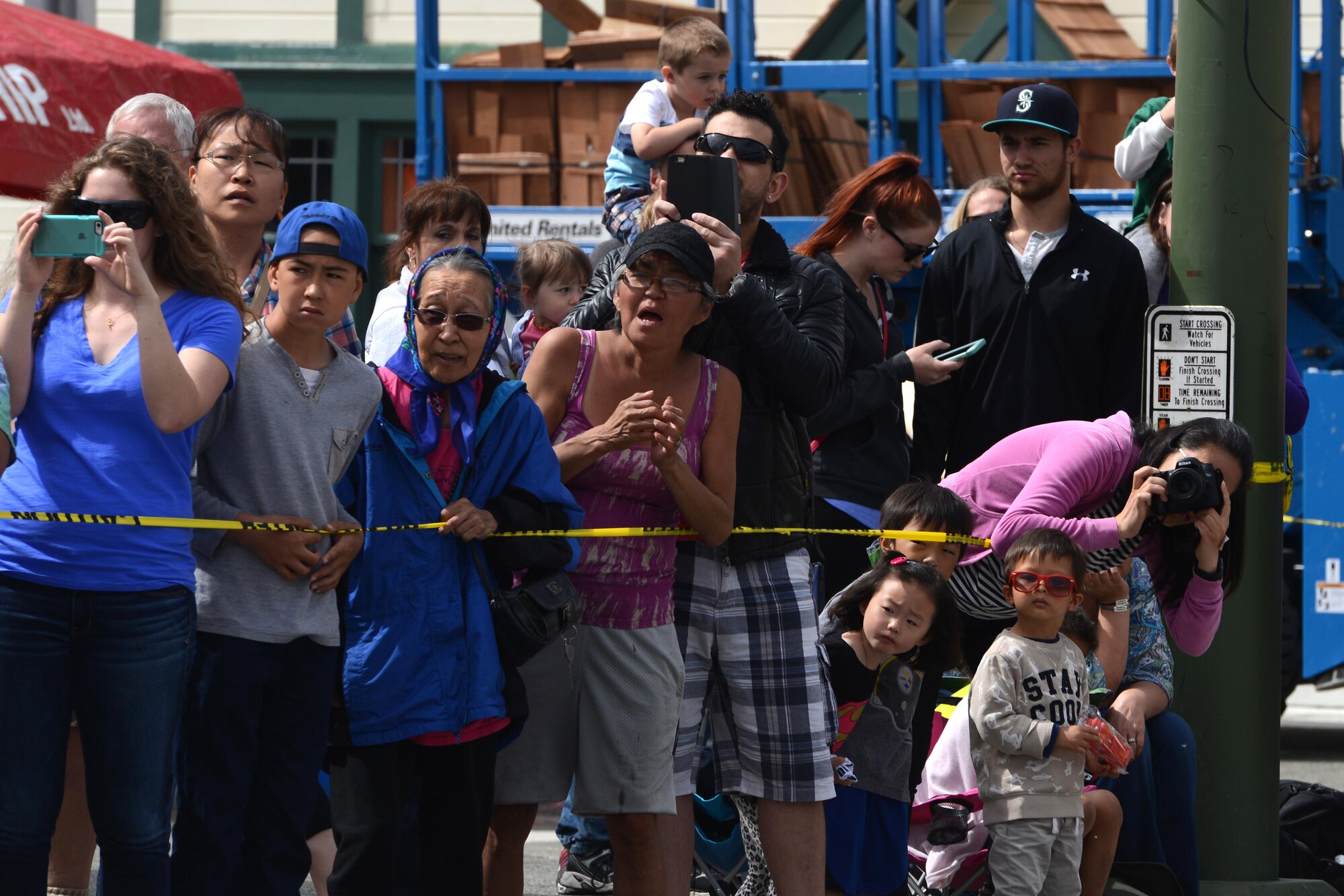 Onlookers take photos and watch the Hero Games during the Downtown Summer Solstice Festival in Anchorage, Alaska, June 18, 2016. Anchorage’s Town Square was surrounded by numerous events and vendors for people to enjoy, including the Hero Games, a friendly competition between Alaska’s first responders with challenges that require balance, strength and teamwork. (U.S. Air Force photo Airman 1st Class Christopher R. Morales)