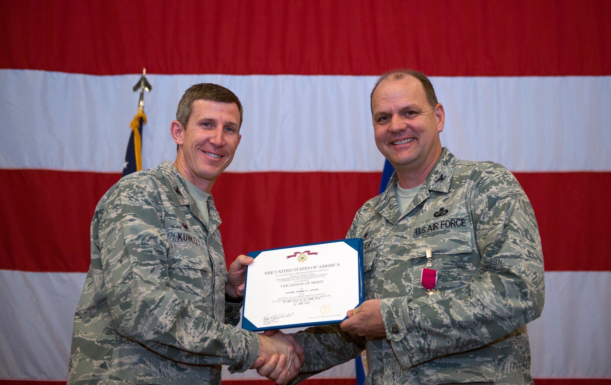 U.S. Air Force Col. Thomas Kunkel, 23d Wing commander, left, presents Col. Norman Dozier, outgoing 23d Mission Support Group commander, with the Legion of Merit award during a change of command ceremony, June 21, 2016, at Moody Air Force Base, Ga. Dozier serviced a community of nearly 28,000 people while also managing 830 base facilities and more than 17 acres of range space during his tenure. (U.S. Air Force photo by Airman 1st Class Greg Nash/Released)