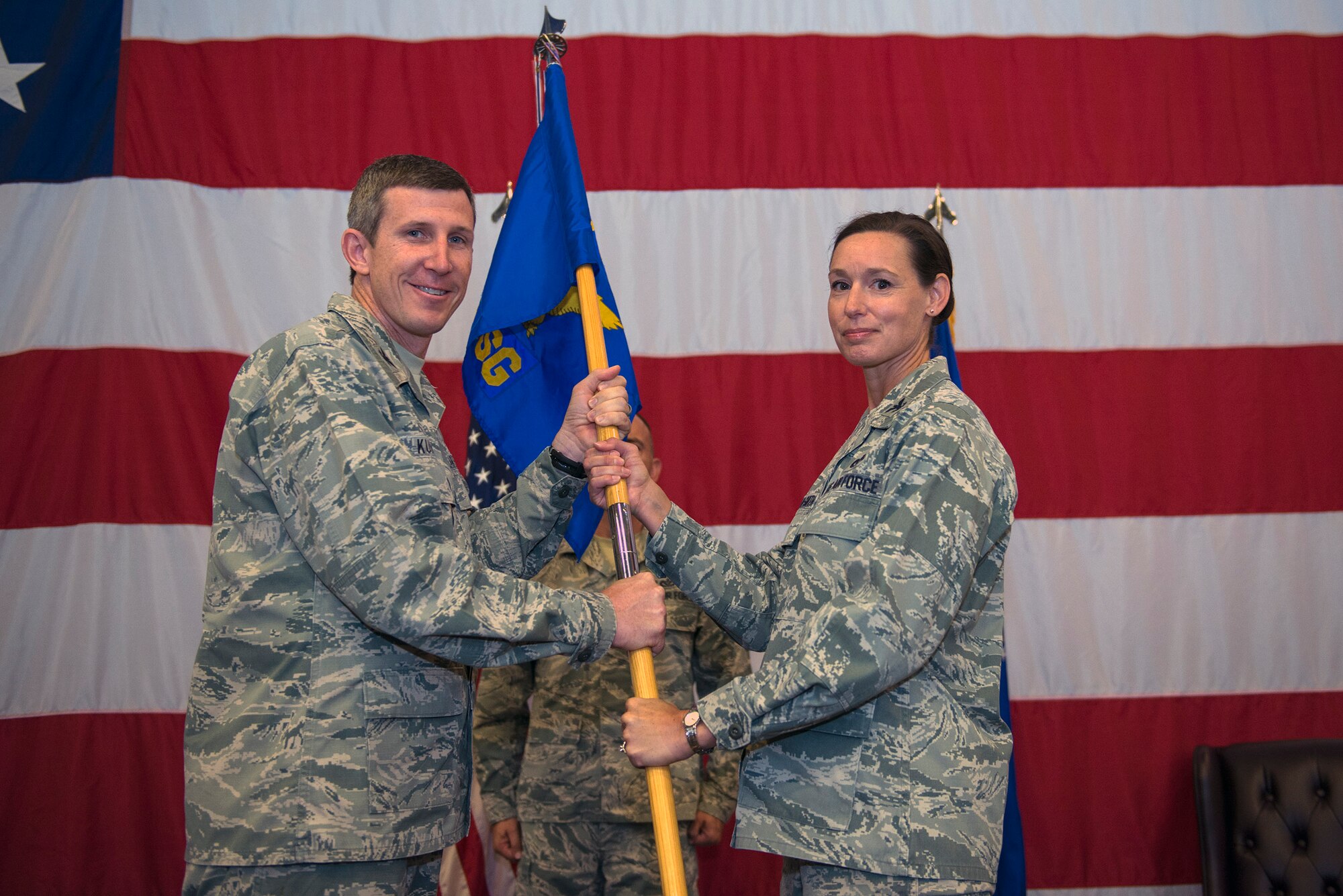U.S. Air Force Col. Thomas Kunkel, 23d Wing commander, presents Col. Susan Riordan-Smith, 23d Mission Support Group commander, with the 23d MSG guidon during a change of command ceremony, June 21, 2016, at Moody Air Force Base, Ga. Riordan-Smith previously served as the deputy director of environmental management directorate at the Air Force Civil Engineer Center at Joint Base San-Antonio Lackland AFB, Texas. (U.S. Air Force photo by Airman 1st Class Greg Nash/Released)