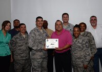 Eloy Salazar, center, 47th Logistics Readiness Flight Traffic Management Office contracting officer representative, accepts the “XLer of the Week” award from Col. Eric Shafa, left, 47th Mission Support Group commander, and Chief Master Sgt. Erica Shipp, right, 47th MSG superintendent, here, June 15, 2016. The XLer is a weekly award chosen by wing leadership and is presented to those who consistently make outstanding contributions to their unit and Laughlin. (U.S. Air Force photo/Senior Airman Jimmie D. Pike)