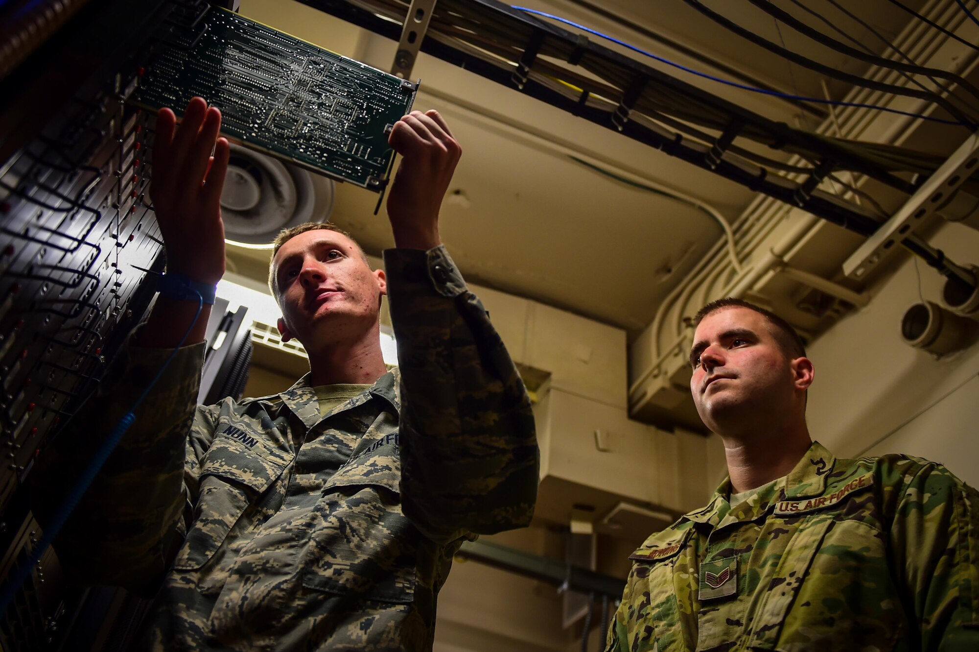 Airman 1st Class Patrick Nunn and Staff Sgt. Kevin Adkins, airfield systems technicians with the 1st Special Operations Support Squadron, examine a circuit board at Hurlburt Field, Fla., June 17, 2016. Airfield systems technicians install, remove and maintain navigation and air traffic control ground-to-air radio systems. (U.S. Air Force photo by Staff Sgt. Christopher Callaway)