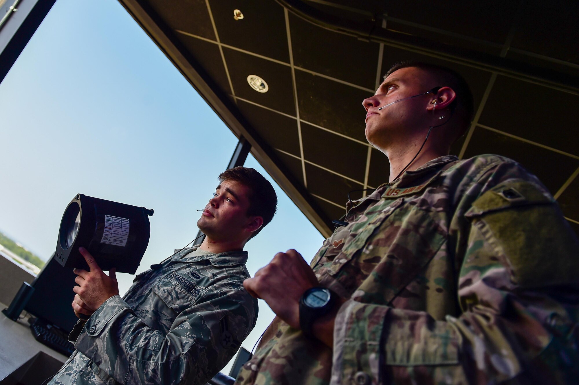 Senior Airman Philip James, an air traffic controller with the 1st Special Operations Support Squadron teaches Airman 1st Class Hollis Read, an air traffic control apprentice with the 1st SOSS how to operate a light gun at Hurlburt Field, Fla., June 17, 2016. The light gun is used to direct air traffic in the air and on the ground when radio communications are unavailable. (U.S. Air Force photo by Staff Sgt. Christopher Callaway)