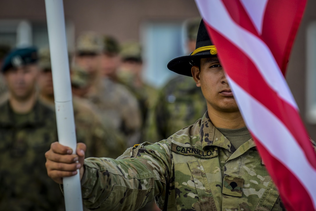A U.S. Army Soldier holds the U.S. flag during a closing ceremony at Tapa Training Base, Estonia, June 21, 2016. U.S. forces in Europe participated in Saber Strike 16; a long-standing, U.S. Joint Chiefs of Staff-directed, U.S. Army Europe-led cooperative-training exercise, which has been conducted annually since 2010. This year’s exercise focused on promoting interoperability with allies and regional partners. The United States has enduring interests in supporting peace and prosperity in Europe and bolstering the strength and vitality of NATO, which is critical to global security. (U.S. Air Force photo/Senior Airman Nicole Keim)