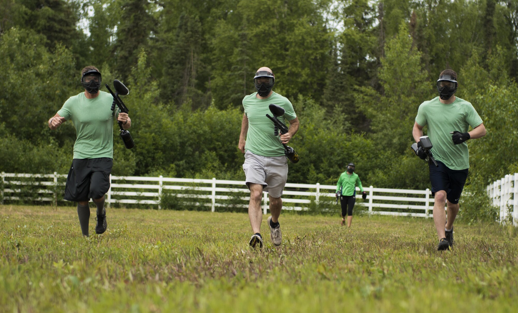 Senior Airman Sebastian Godsey, a 673d Medical Group, Pediatric Flight medical technician (left), Air Force Capt. Aaron Johnston, 673d MDG pediatrician (center), and Airman 1st Class Jacob Edgell, 673d MDG, Pediatric Flight medical technician run the perimeter of an old horse race track as their first challenge for the Dirty Dozen June 10. After completing a circle of the track, they worked their way through a paintball target range. (U.S. Air Force photo by Senior Airman Kyle Johnson)