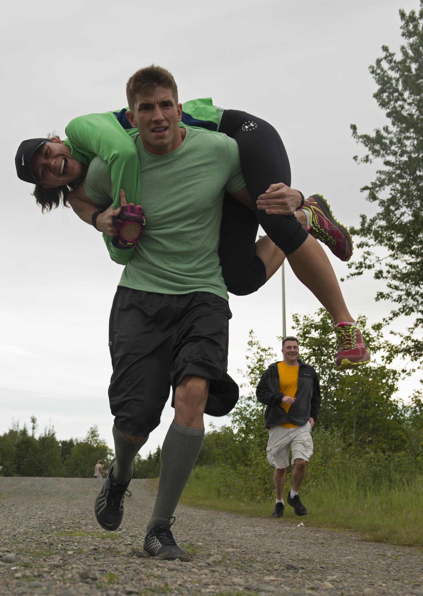Senior Airman Sebastian Godsey, a 673d Medical Group, Pediatric Flight medical technician and Little Rock, Ark. native, carries Tech. Sgt. Jennifer Patronas, 673d MDG, Pediatric Flight, flight chief to a memory challenge in a fireman's carry. Competitors memorized four codes to four different locks, then fireman carry their teammates down to use the codes. They were free to go back and forth between lock and code - if they fireman carried a teammate. (U.S. Air Force photo by Senior Airman Kyle Johnson)