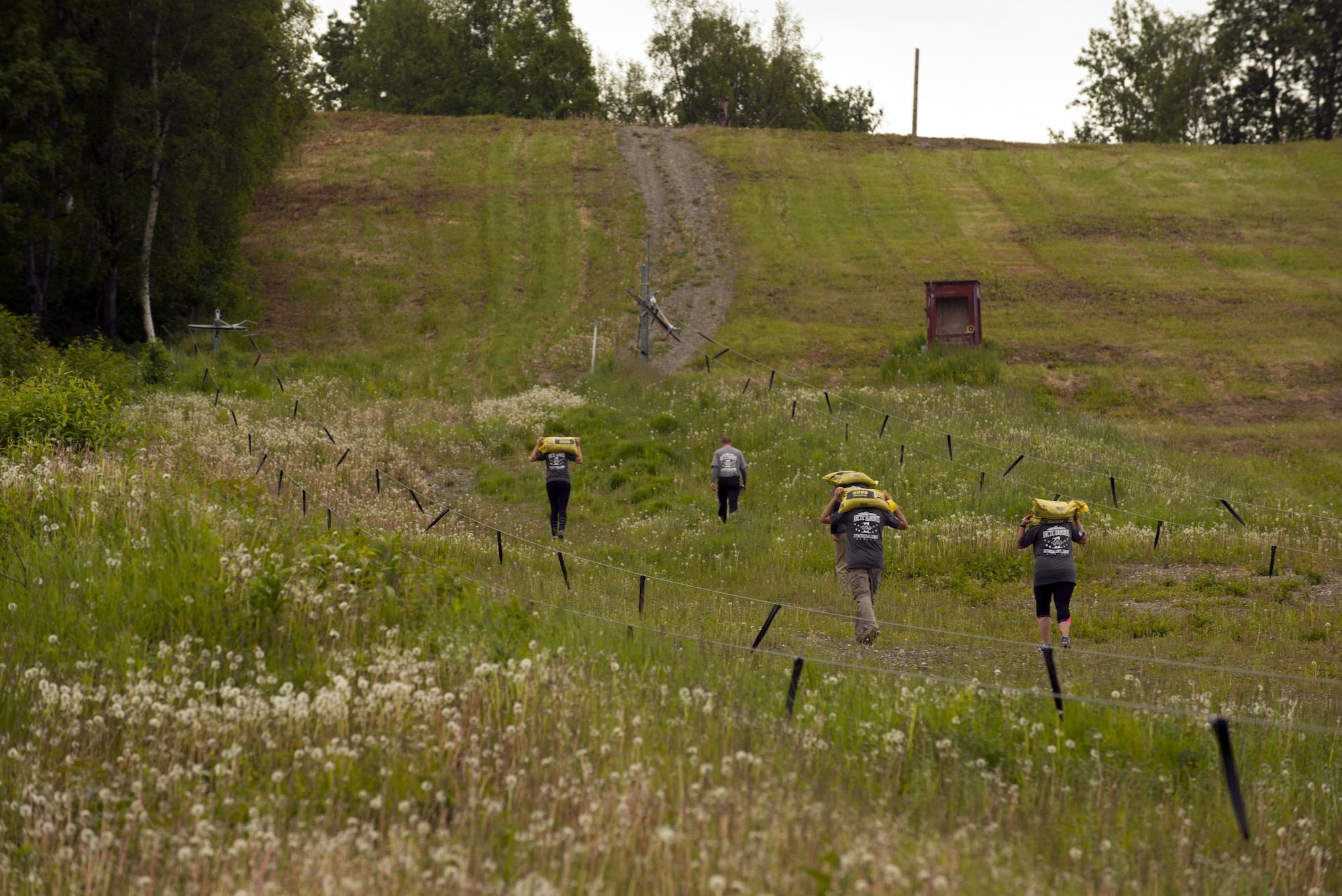 Dirty Dozen competitors haul sandbags up and down the Hillberg Ski Area slope as the eleventh challenge in the Dirty Dozen June 10. Each team had four participants who made their way through 12 physical, intellectual and tactical challenges in a contest to best the other team's times. (U.S. Air Force photo by Senior Airman Kyle Johnson)