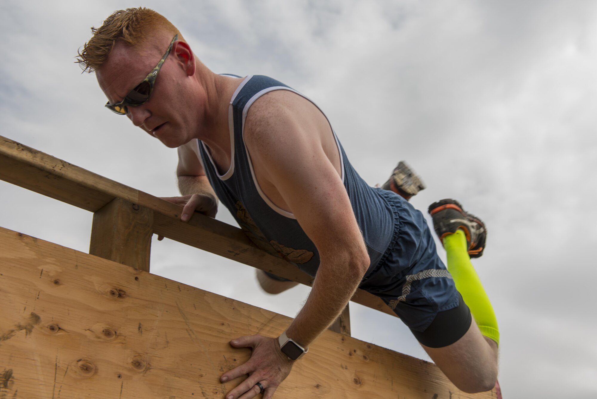 Air Force Staff Sgt. Nathan Schiers, 962nd Airborne Air Control Squadron communications operator and Haily, Idaho native, flings himself over a wooden wall as part of the Dirty Dozen challenge June 10. Dirty Dozen is a chain of 12 stations, each testing the team's competency in intellectual and physical challenges. Schiers' team, 'Rub Some Dirt on It' placed second overall. (U.S. Air Force photo by Senior Airman Kyle Johnson)
