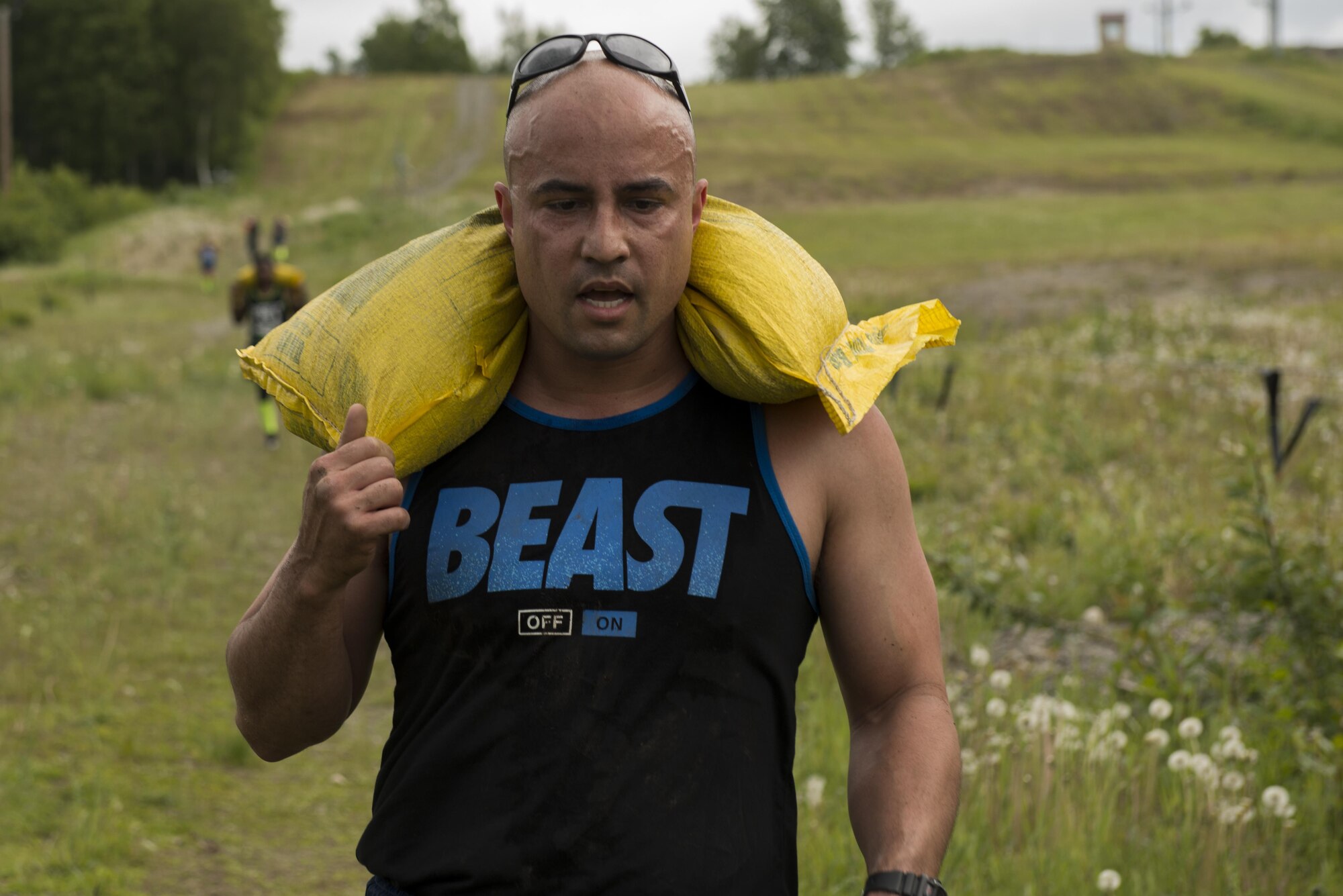 Air Force Capt. Robert Crespo, a 962nd Airborne Air Control Squadron pilot from Edmond, Okla. carries a sandbag up and down the Hillberg Ski Area slope as part of the Dirty Dozen challenge June 10. Each team had four participants who made their way through 12 physical, intellectual and tactical challenges in a contest to best the other team's times. (U.S. Air Force photo by Senior Airman Kyle Johnson)