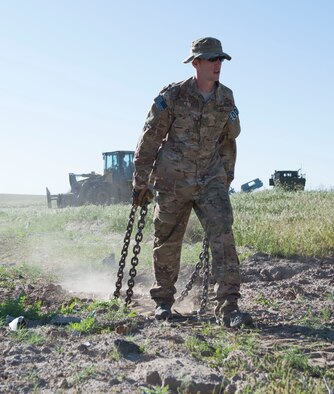 An explosive ordnance disposal member from the 366th Civil Engineer Squadron drags chains to the next location where inert explosives will be extracted at Saylor Creek Range Complex, Idaho, May 9, 2016. There are approximately 97,000 acres of Air Force-owned, joint-use land around Saylor Creek Range where public access is permitted. (U.S. Air Force photo by Airman 1st Class Chester Mientkiewicz/Released)