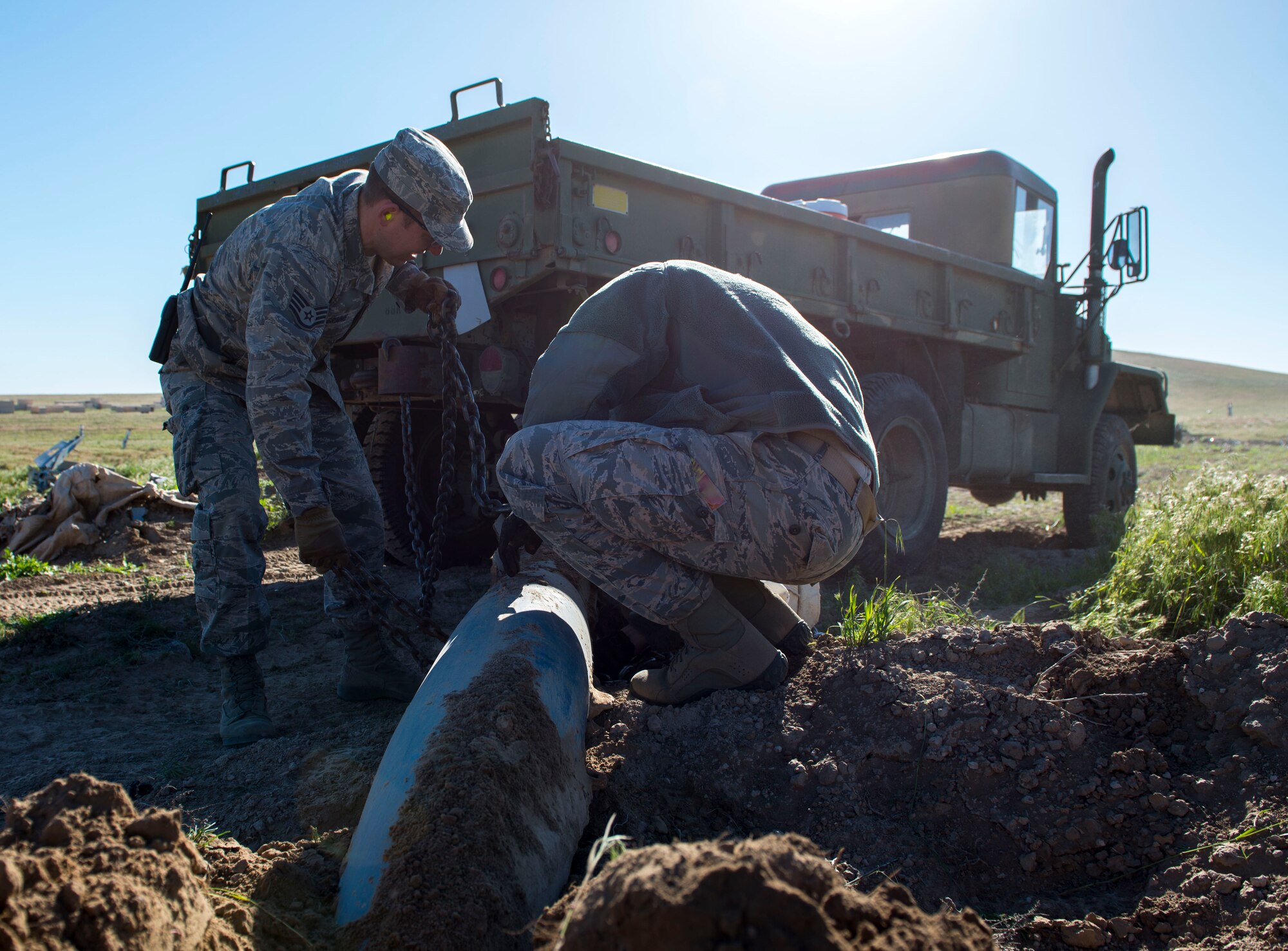 Airmen from the 366th Civil Engineer Squadron prepare for an inert GBU-12 Paveway II extraction during a range clearance at Saylor Creek Range Complex, Idaho, May 9, 2016. The range clearance ensures individuals training on the range avoid injuries from explosives dropped in the past. (U.S. Air Force photo by Airman 1st Class Chester Mientkiewicz/Released)