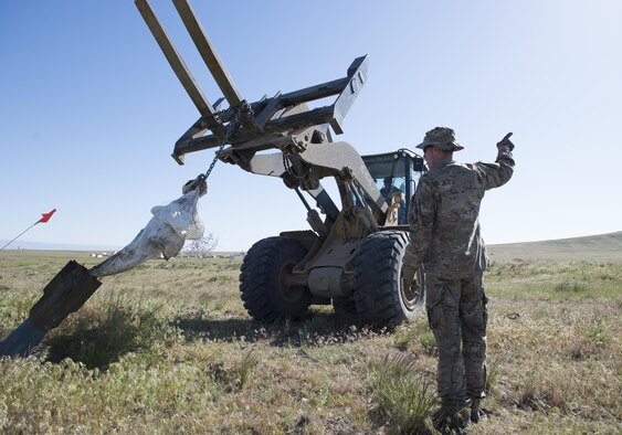 Airmen from the 366th Civil Engineer Squadron extract inert explosives using a shovel loader with fork attachments during a range clearance at Saylor Creek Range Complex, Idaho, May 9, 2016. The 366th Fighter Wing at Mountain Home Air Force Base, Idaho operates, maintains and develops the Mountain Home Range Complex which is comprised of 7,400 square miles of associated airspace and 122,000 acres of land space used for two air-to-ground training ranges, five no-drop target complexes and 30 multi-size electronic combat sites. (U.S. Air Force photo by Airman 1st Class Chester Mientkiewicz/Released)