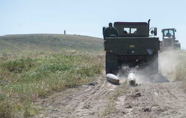 Members from the 366th Civil Engineer Squadron drag inert explosives behind a five-ton truck as airmen gather explosive ordnance during a range clearance at Saylor Creek Range Complex, Idaho, May 9, 2016. The range clearance is a quarterly event held by explosive ordnance disposal ensuring improved safety to individuals training there. (U.S. Air Force photo by Airman 1st Class Chester Mientkiewicz/Released)
