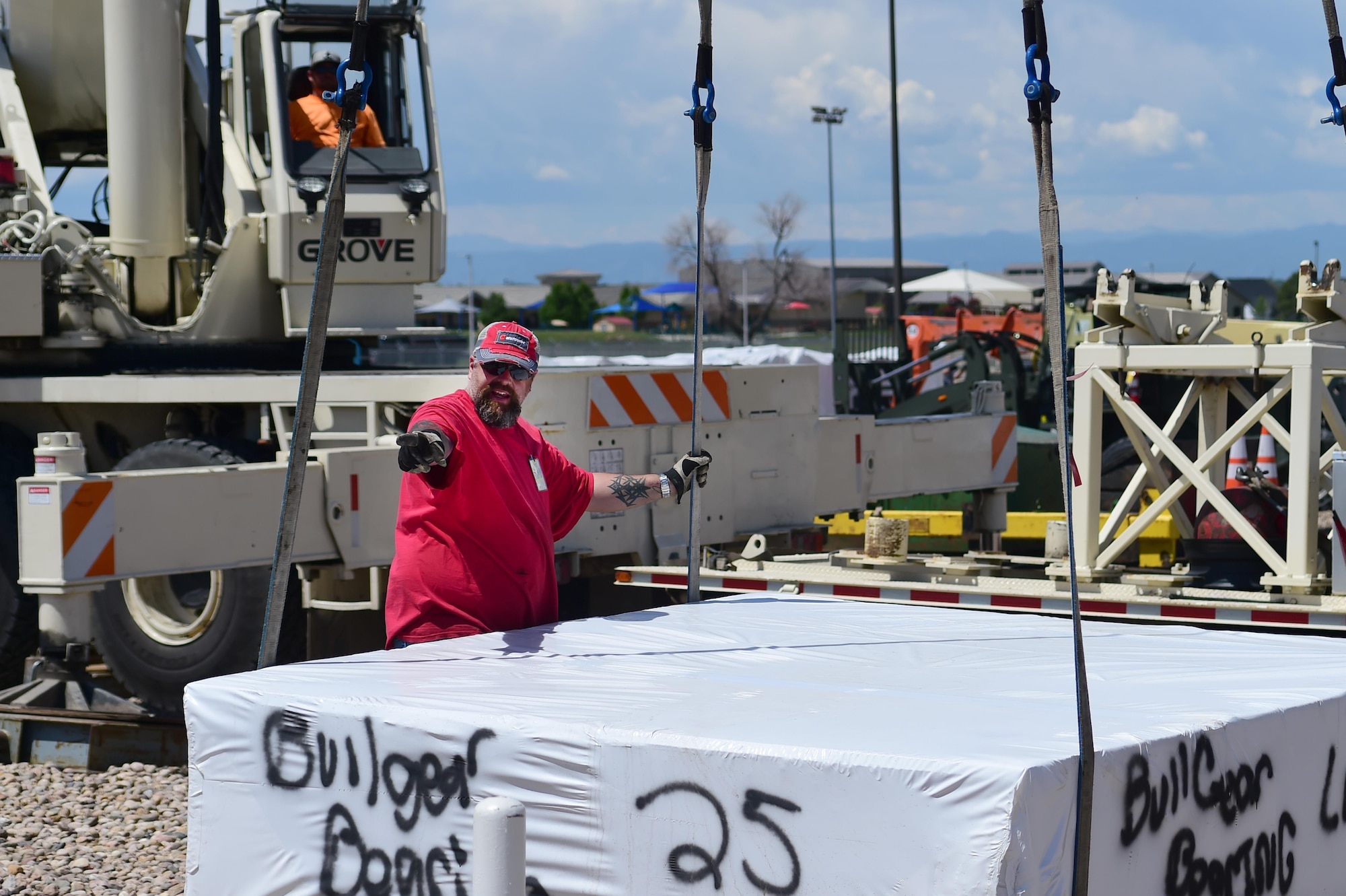 A construction worker guides a piece of the new terminal into place June 6, 2016, on Buckley Air Force Base, Colo. The installation of a new terminal is part of the Modernization of Earth Terminals project. The project aims to replace decades old terminals with new ones that enhance communications and capabilities. (U.S. Air Force photo by Airman 1st Class Luke W. Nowakowski/Released)