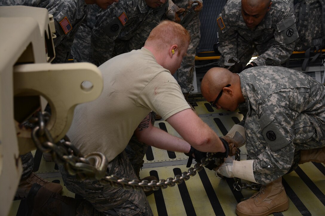 Soldiers from the 1397 Deployment and Distribution Support Battalion, among other units, gather June 18, 2016, to observe Senior Airman Joshua Thomas, 55th Aerial Port Squadron, train Army Specialist Mijjal Tamrakar on how to secure a Light Medium Tactical Vehicle. The training took place during a larger Rodeo event hosted by the 45th APS on Travis Air Force Base. (U.S. Air Force photos/Staff Sgt. Madelyn Brown)