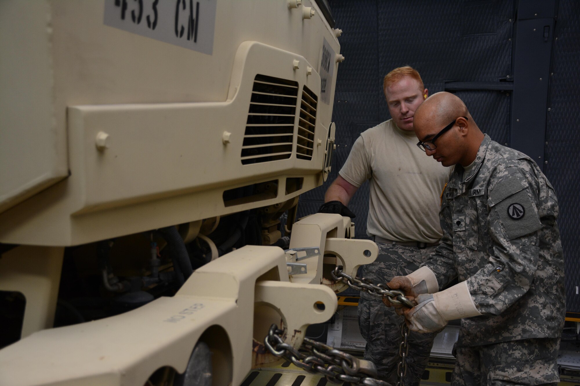 Senior Airman Joshua Thomas, 55th Aerial Port Squadron, trains Army Specialist Mijjal Tamrakar on how to secure a Light Medium Tactical Vehicle June 18, 2016. The training took place during a larger Rodeo event hosted by the 45th APS on Travis Air Force Base.  (U.S. Air Force photos/Staff Sgt. Madelyn Brown)